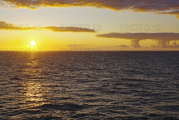 Sunset over the sea with yellow reflections on the waves, Orkney Islands, Scotland, Great Britain