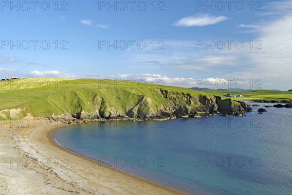 Sandy beach beach and blue sea with green cliffs under a clear sky, Eshaness, Shetland Islands, Scotland, United Kingdom