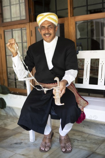 Indian man, 63 years old, from the Kodava clan in traditional dress showing a traditional dagger sheath, Coorg, Karnataka, India