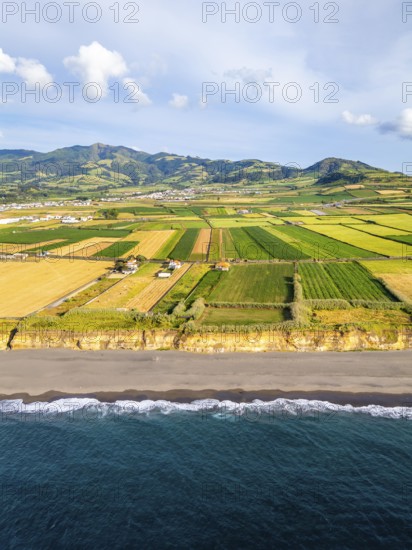 Santa Barbara Beach, Green Lush Fields with Pasturelands and Atlantic Ocean. Mountains on Background. Azores, Sao Miguel Island. Portugal. Aerial View