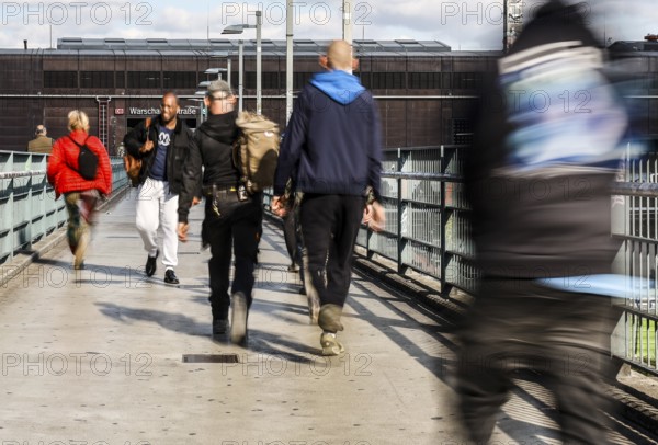 People walking across a bridge at Warschauer Straße station, Berlin, 02 October 2025, Berlin, Berlin, Germany