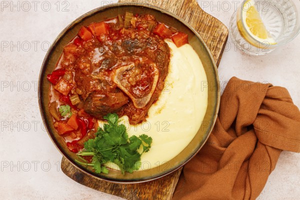Ossobuco, stewed meat knuckle on the bone, with mashed potatoes, and oats and spices, homemade, no people