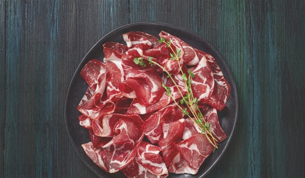 Plate with sliced cured meat, pork neck, prosciutto coppa, Italian delicacy