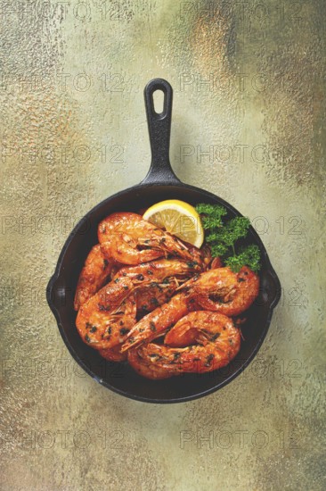 Fried white-footed shrimp, tiger shrimp baths, in a cast-iron skillet, with lemon and herbs, no people