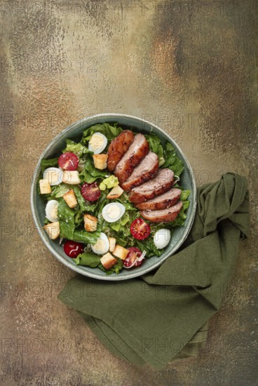 Caesar salad, with duck breast, on a green plate, homemade, no people