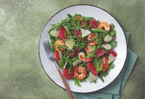 Fresh shrimp salad with arugula, grapefruit, and parmesan served in a bowl