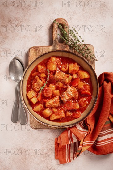 Meat goulash with potatoes and carrots, sweet peppers, in a saucepan, top view, traditional Hungarian soup, homemade, no people