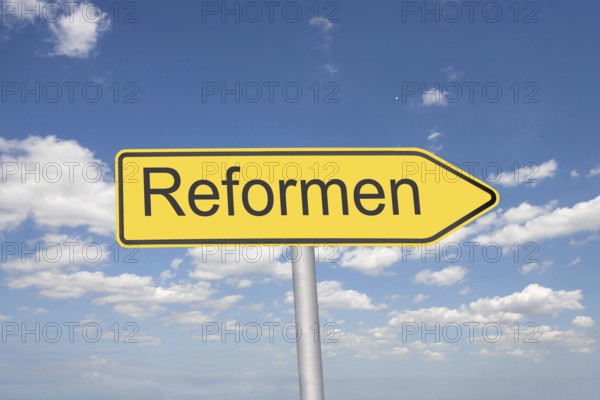 (Photomontage) Directional arrow with the inscription REFORMEN in front of a blue sky