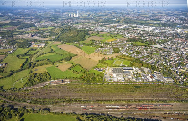 Aerial view, marshalling yard Hamm, industrial area Schieferstraße and slag heap Kissinger Höhe and slag heap Humbert, CreativRevier Hamm, former mine Ost Heinrich Robert, view to RWE Generation SE power plant Gersteinwerk with chimney and cooling towers, district Pelkum, Hamm, Ruhr area, North Rhine-Westphalia, Germany, railway area, slag heap, CreativRevier Heinrich Robert, DE, Deutsche Bahn AG, Europe, commercial enterprise, commercial area, commercial area, commercial property, commercial location, commercial use, railway tracks, tracks, property tax, goods trains, real estate, industrial area, industrial location, aerial view, aerial photography, aerial photography, overview, bird's-eye view, residential area, residential area, residential quality, residential neighbourhood, residential estate, residential district, birds-eyes view, overview