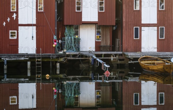 Boats and falun red boathouses in the harbour of Smögen, Smögenbryggan, Västra Götalands Län, Bohuslän, Sweden