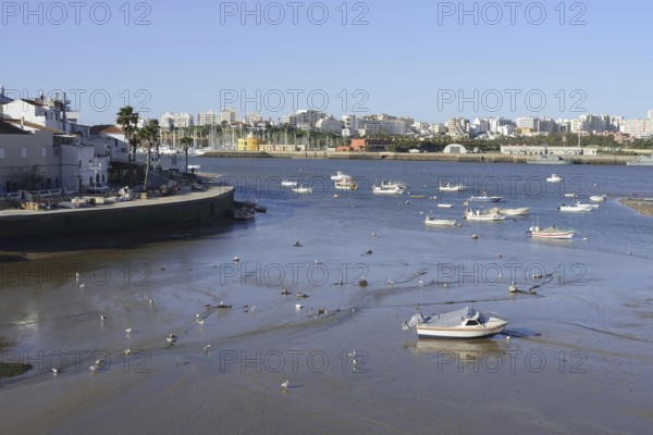 View over the mouth of the river Arade with fishing boats to Portimao, Ferragudo, Algarve, Portugal