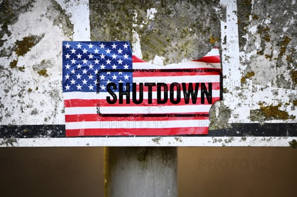 Torn sticker of US flag with shutdown printed on it, photomontage