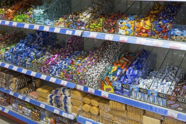 Shelves full of colourful candy wrappers and biscuits in a supermarket, affordable prices and variety, Gntunik supermarket, Aragazotn province, Armenia