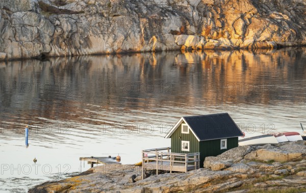 Small green boathouse, evening mood at sunset, Smögen, Smögenbryggan, Västra Götalands Län, Bohuslän, Sweden