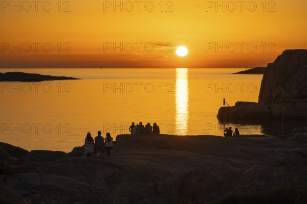 Silhouettes of tourists, sun melting in the sea, sunset, archipelago landscape, Smögen, Smögenbryggan, Västra Götalands Län, Bohuslän, Sweden