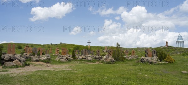 Panoramic view of a landscape with stone pillars and peaceful surroundings under a blue sky, monument of the Armenian alphabet, Aparan, Aragazotn province, Armenia