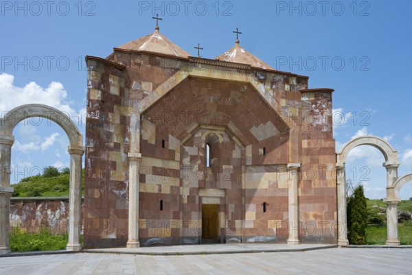 Front view of a stone church with striking arches and three crosses on the roof, Saint Trinity Altar of Hope, Aparan, Aragazotn Province, Armenia
