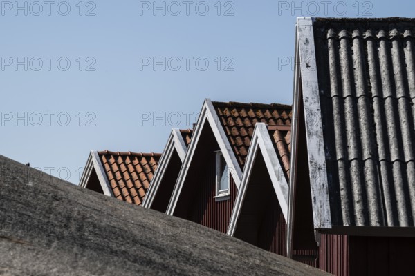 Gable of boat shed behind a rock, girl jumping from a high wooden diving platform, lido, Fjällbacka, Bohuslän, West Sweden, Sweden