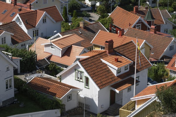 Bird's eye view of traditional, white Scandinavian wooden houses with orange-red roofs, Fjällbacka, Bohuslän, West Sweden, Sweden