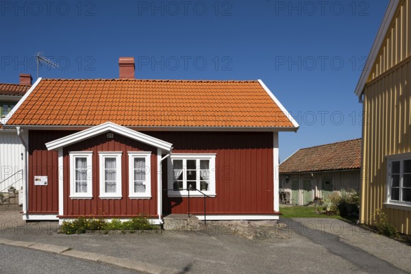 Red wooden house under a bright blue sky, typical Swedish style, Fjällbacka, Bohuslän, West Sweden, Sweden