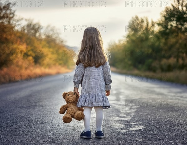 A young child stands alone holding a teddy bear in an urban outdoor setting, symbolizing innocence and isolation, AI generated