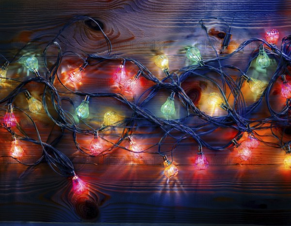 Vivid string lights in captivating colors arranged on a wooden surface, perfect for evoking a festive and cheerful atmosphere in artistic and celebratory settings, AI generated