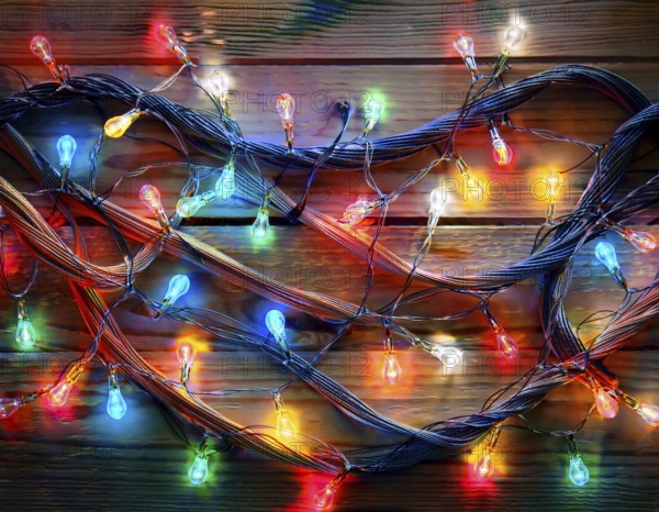 Vivid string lights in captivating colors arranged on a wooden surface, perfect for evoking a festive and cheerful atmosphere in artistic and celebratory settings, AI generated