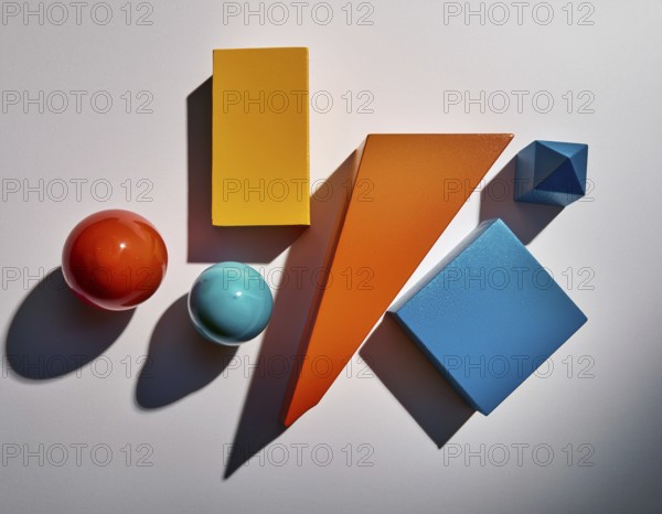 Vividly colored geometric shapes, including spheres and pyramids, artfully arranged on a surface. Captured with vibrant lighting and pronounced shadows, this image showcases diversity in form and artistic composition, AI generated