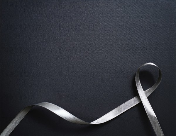 A beautifully wrapped gift box adorned with colorful satin ribbons forming a bow, contrasting against a linear textured surface, evoking feelings of celebration and elegance, AI generated