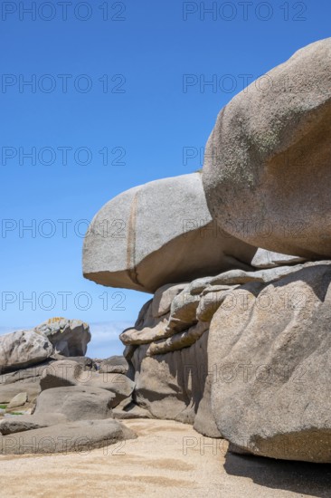 Spectacular pink granite rocks, sculpted by wind and sea, pile up on the beach of the Cote de Granit Rose, while the clear, turquoise-blue water reveals seaweed and light-coloured sand on the seabed at low tide, Tregastel, Cotes-d'Armor department, Brittany region, France