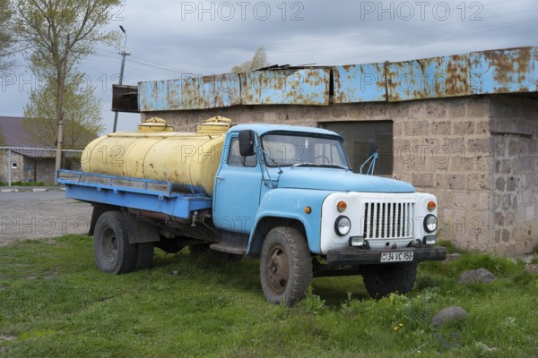 An old blue lorry with yellow tanks stands abandoned in a rural setting, GAZ-53 lorry, tanker, Armenia