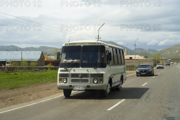 A bus travelling on a road along a rural and mountainous landscape with a cloudy sky, PAZ-3205 Bus, Armenia
