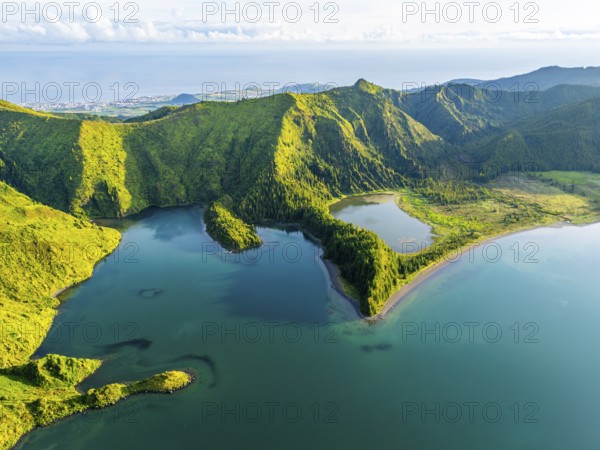 Lagoa do Fogo Lake on Sunny Morning. Green Lush Hills, Mountains and Atlantic Ocean. Azores, Sao Miguel Island. Portugal. Aerial Drone Shot