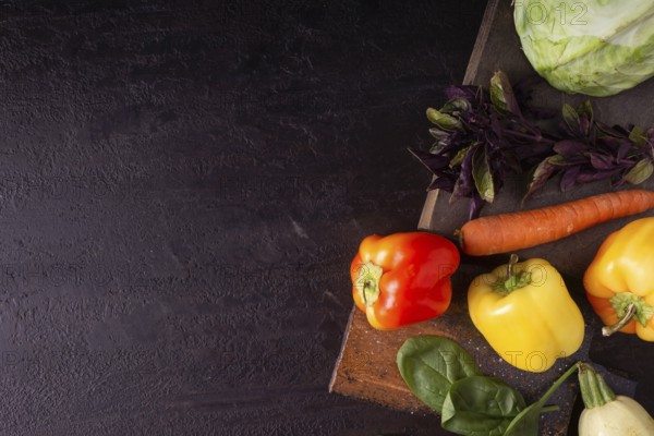 Cabbage, peppers, zucchini, greens, carrots on a wooden board space for text