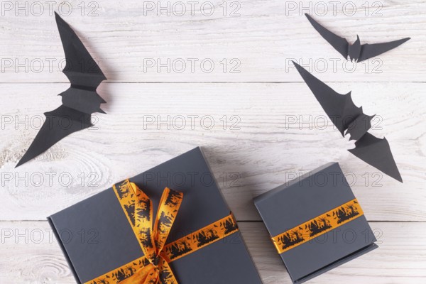 A pair of gray boxes tied with an orange ribbon, with drawings on the theme of Halloween copy space