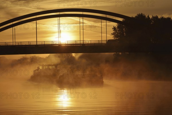 Ship on the Datteln-Hamm Canal in the morning fog at sunrise, Bergkamen, North Rhine-Westphalia, Germany