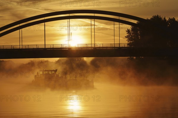 Ship on the Datteln-Hamm Canal in the morning fog at sunrise, Bergkamen, North Rhine-Westphalia, Germany