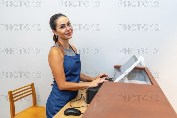 Young female entrepreneur managing sales and finances, operating a modern pos system in her trendy store