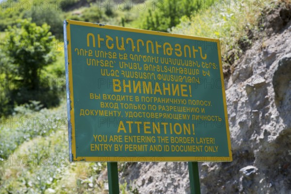 A multilingual warning sign regulating access to the border zone, sign in front of a military post on the border with Azerbaijan, near Goris, Armenia