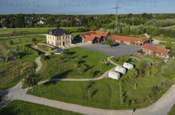 Dortmund, Castrop-Rauxel, North Rhine-Westphalia, Germany - The Hof Emscher-Auen, café and canal pipe hotel, in Castrop-Rauxel is located on the largest dam in the Emscher region at the HRB Mengede flood retention basin. River renaturalisation, renaturation of the Emscher. A new floodplain landscape is being created at the Emscher-Auen farm, expanding the area for flood protection during heavy rainfall and for biodiversity. The previously straightened Emscher is being given curves again and can meander through its new floodplain. Following the construction of a parallel sewer, the Emscher has been completely free of sewage since 2022. The river was previously an open, above-ground combined sewer with rainwater and wastewater
