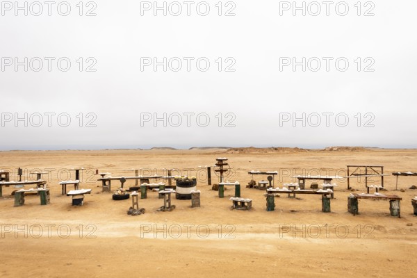 Pink salt displayed on wooden stands along the road to Namib-Naukluft National Park and Sandwich Harbour, Namibia, set against a desert landscape