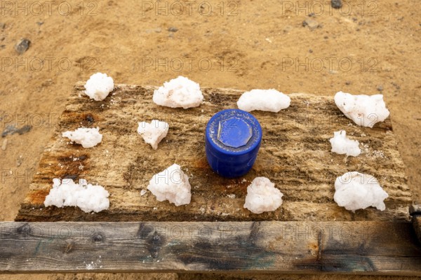 Pink salt displayed on wooden stands along the road to Namib-Naukluft National Park and Sandwich Harbour, Namibia, set against a desert landscape