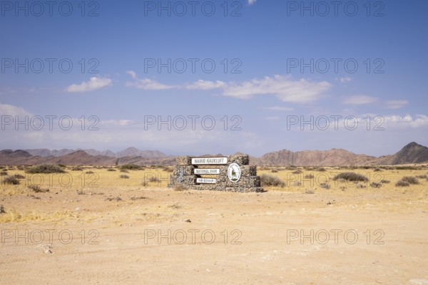 Stone entrance sign of Namib-Naukluft National Park in Namibia- 27 August, 2025: surrounded by desert plains and distant mountain ranges