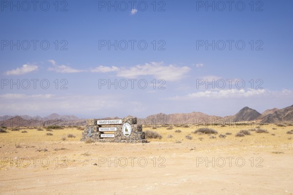 Stone entrance sign of Namib-Naukluft National Park in Namibia- 27 August, 2025: surrounded by desert plains and distant mountain ranges