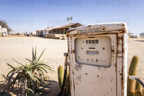Old rusty fuel pump in Solitaire, Namibia - 27 August, 2025: set in a desert landscape with cacti, aloe plants, and rustic buildings under a clear blue sky