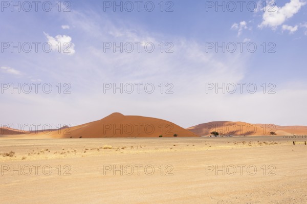 Sossusvlei in Namibia is a desert wonder, famous for its giant red dunes, glowing at sunrise and sunset, and its hauntingly beautiful dead tree valleys