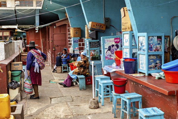 Lively street scene at a Bolivian market with people in traditional clothing and colourful chairs, market stall in the market halls of Potosi Bolivia