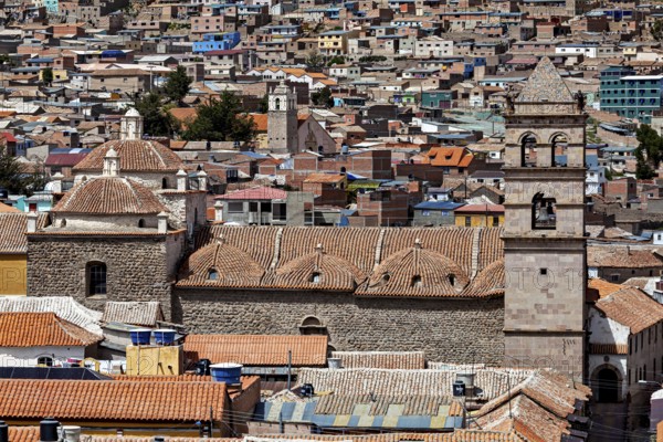 Densely built-up city scene with brick towers and colonial architecture in the foreground, The churches of the city of Potosi in Bolivia
