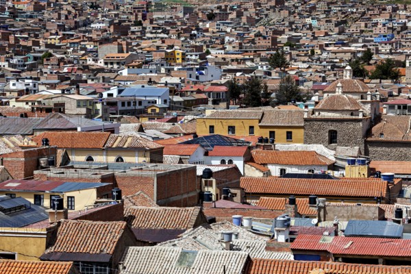 A multitude of densely packed buildings with colourful roofs in a lively urban area, view over the city of Potosi in Bolivia