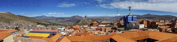 Panoramic view of a city with orange-coloured roofs, surrounded by mountains and bright sunshine, view over the city of Potosi in Bolivia